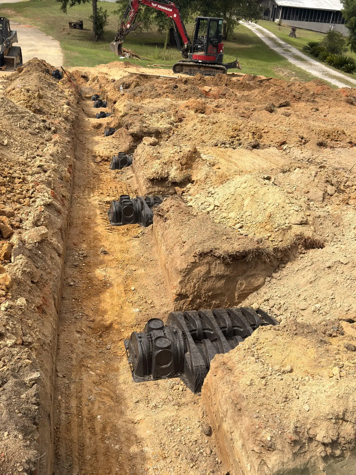 Trench with chambers installed and an excavator in the background