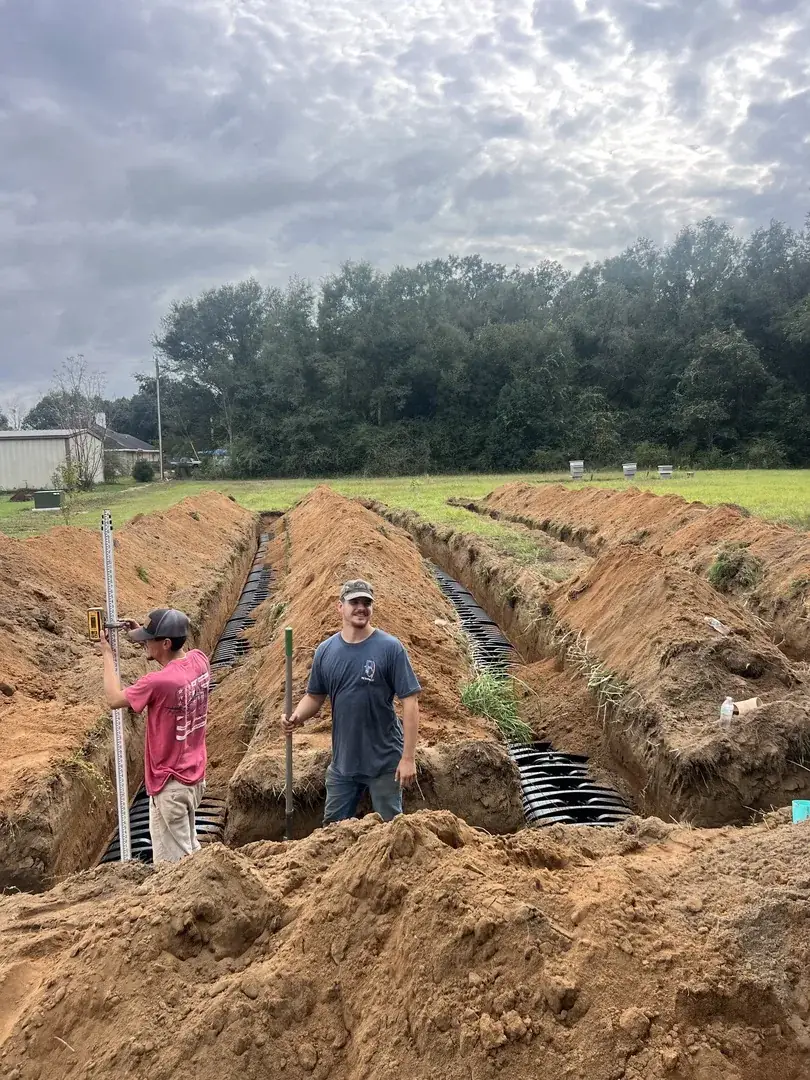 Crew inspecting drain field trenches on site