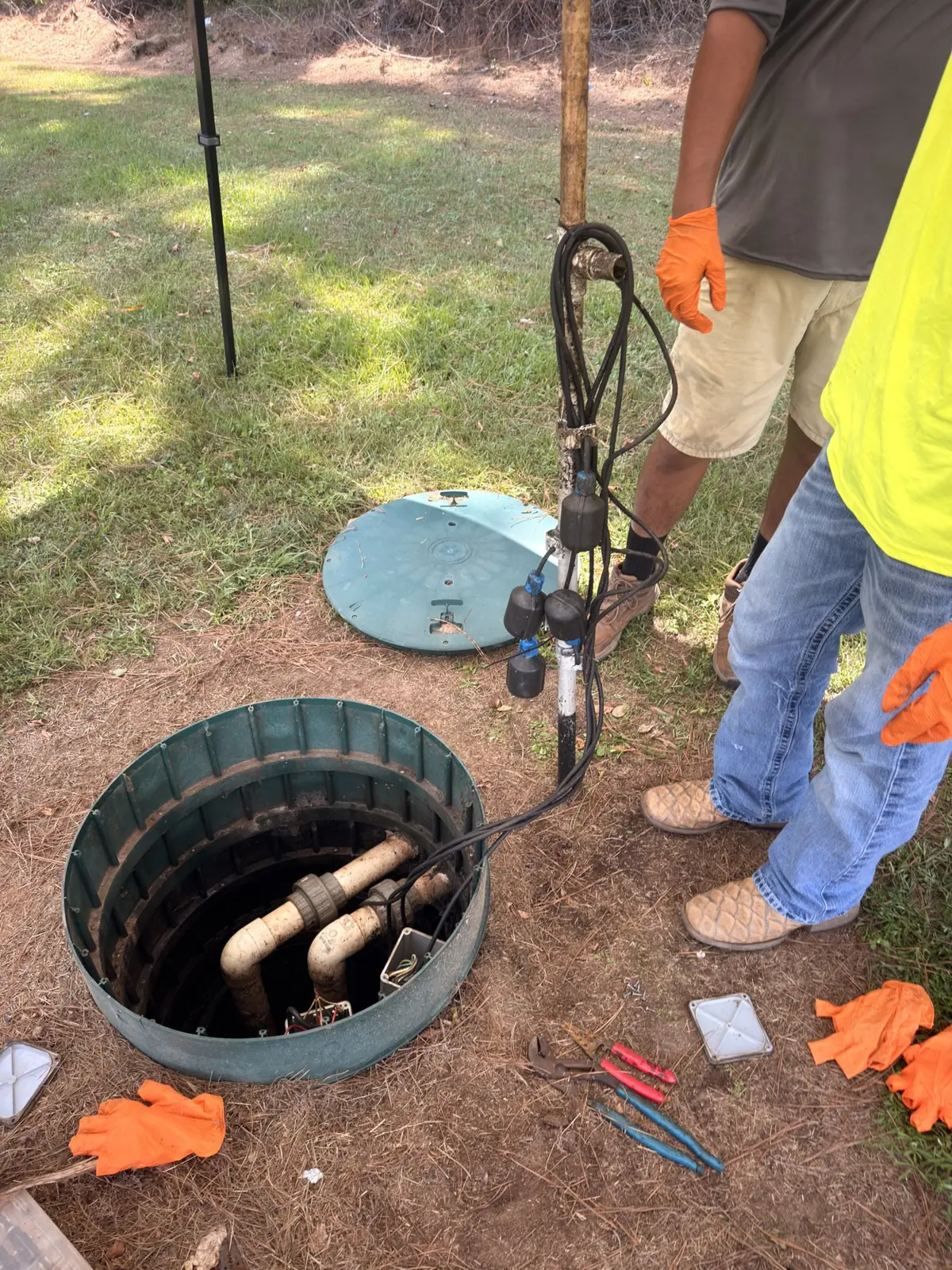 Technicians servicing a pump basin