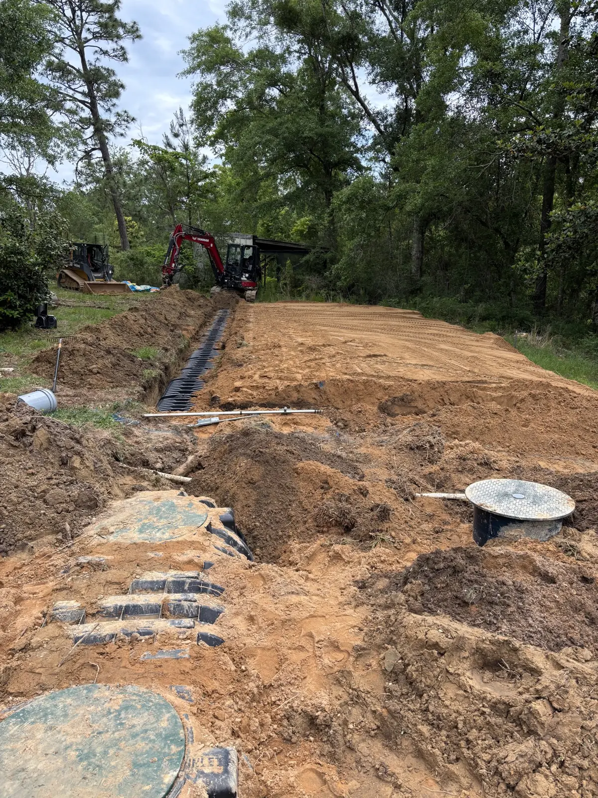 Tank lids and a chamber trench on a wooded lot