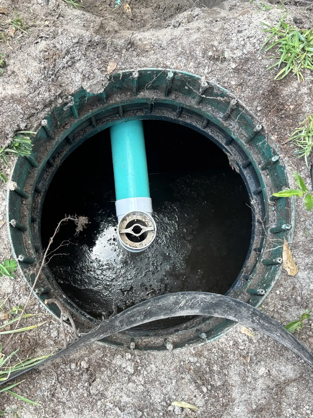 Inside a septic tank riser with the outlet pipe visible